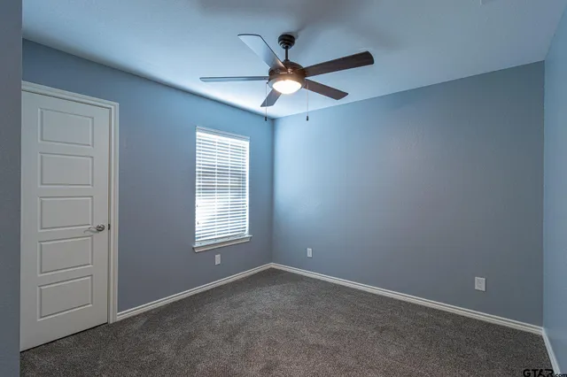 an empty room with closet and windows