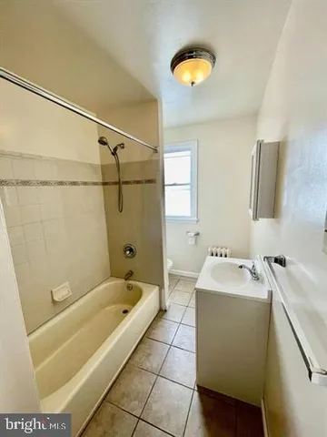 an empty room with chandelier fan and windows