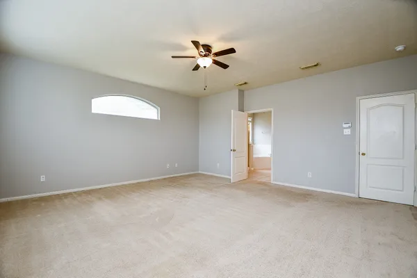 an empty room with a ceiling fan and a window