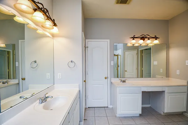 a bathroom with a tub a sink and a mirror
