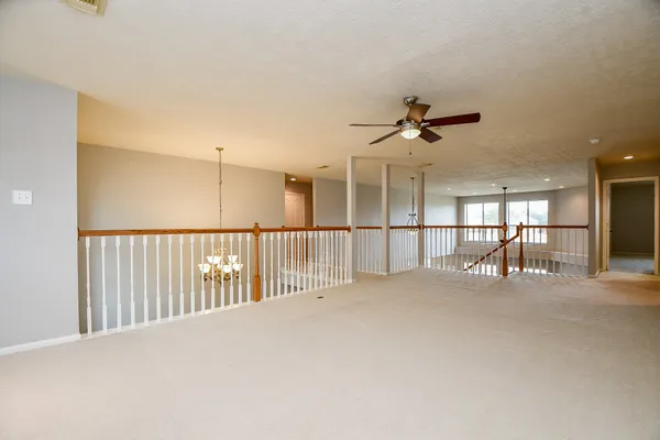a view of a hallway with a ceiling fan