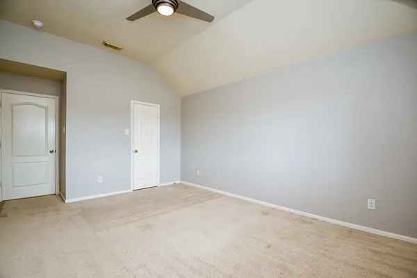 an empty room with a window and a fan
