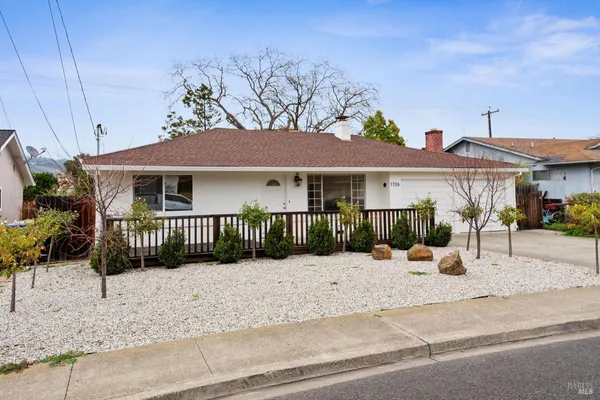 a view of a house with a yard and sitting area