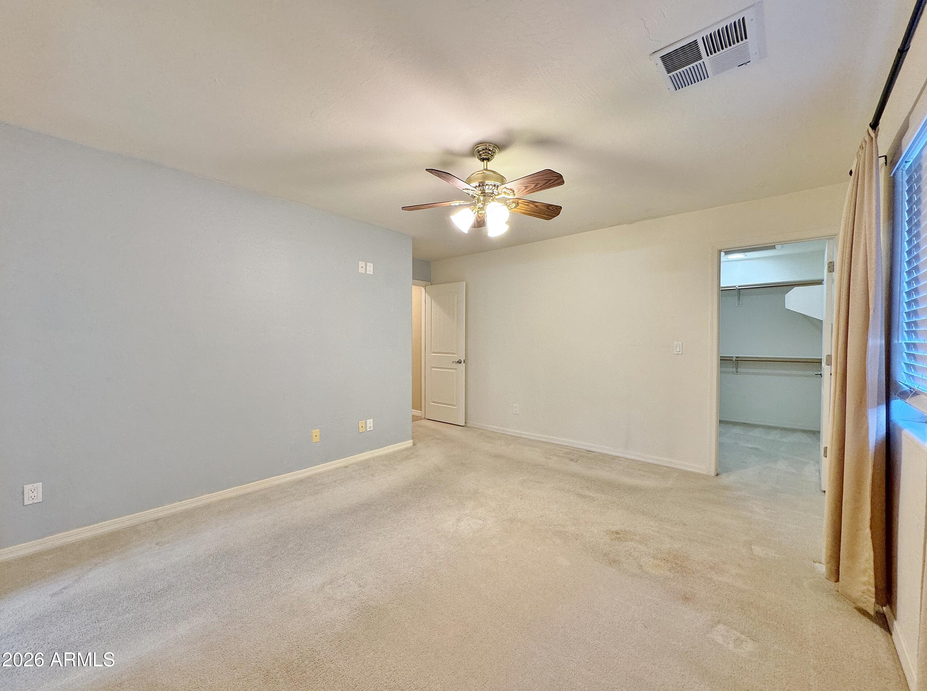 15774 South Saxon Road Arizona City, AZ 85123 - Photo 20 of 53 an empty room with a chandelier fan and windows