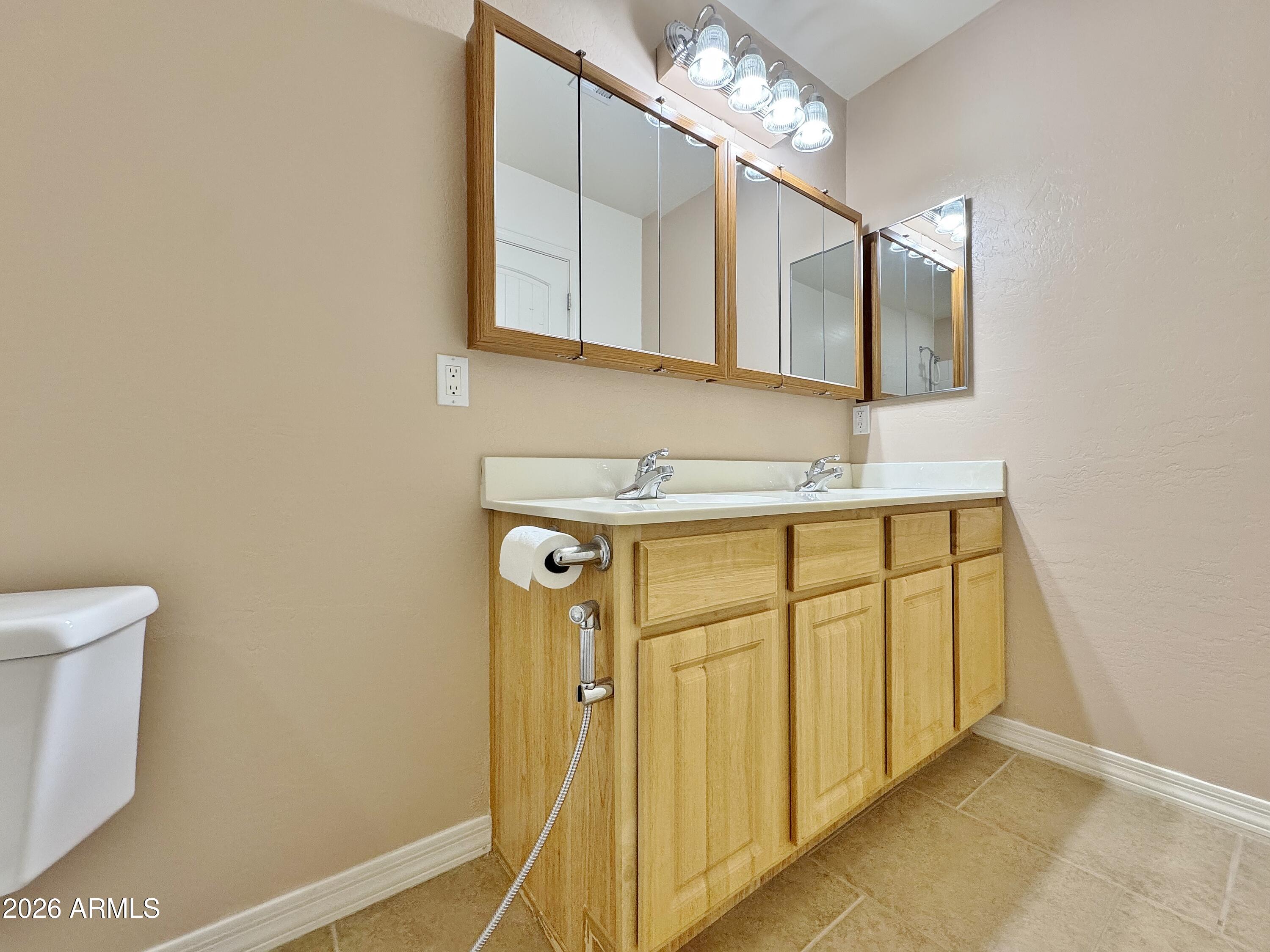 15774 South Saxon Road Arizona City, AZ 85123 - Photo 22 of 53 a bathroom with a sink a mirror and a toilet