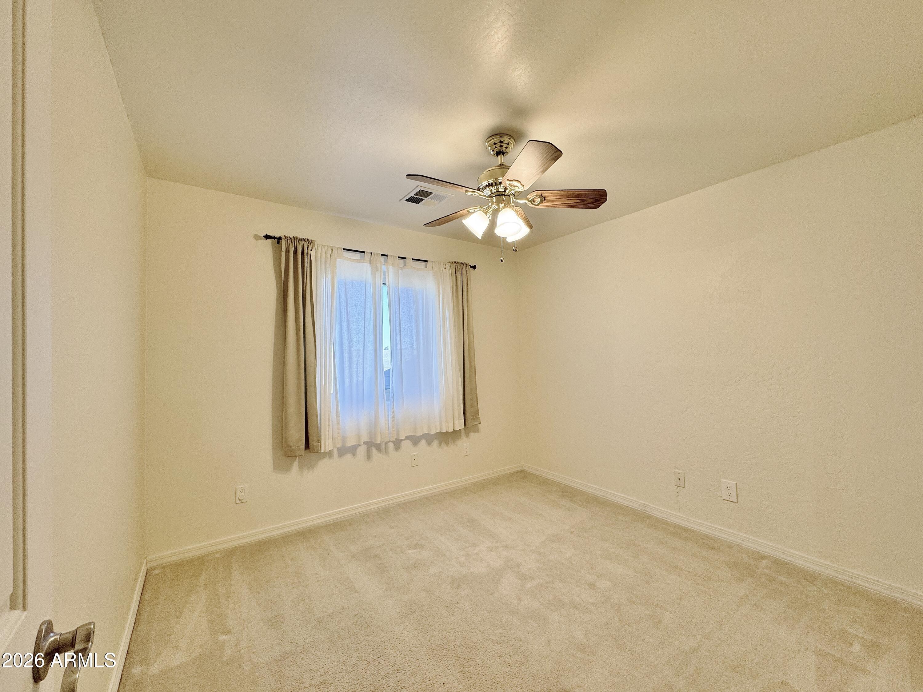 15774 South Saxon Road Arizona City, AZ 85123 - Photo 28 of 53 an empty room with a chandelier fan and windows
