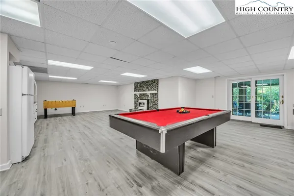 a room with pool table windows and wooden floor