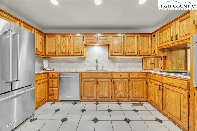 a kitchen with stainless steel appliances granite countertop a stove a sink and a refrigerator