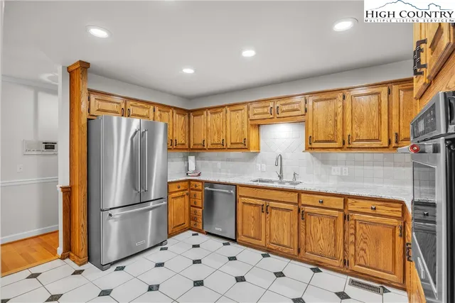 a kitchen with stainless steel appliances a refrigerator sink and cabinets