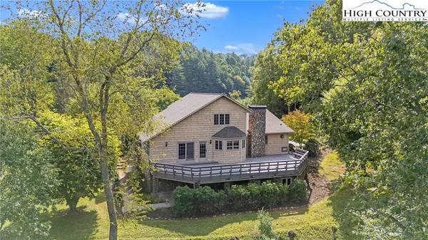 a view of a house with a small yard plants and large tree
