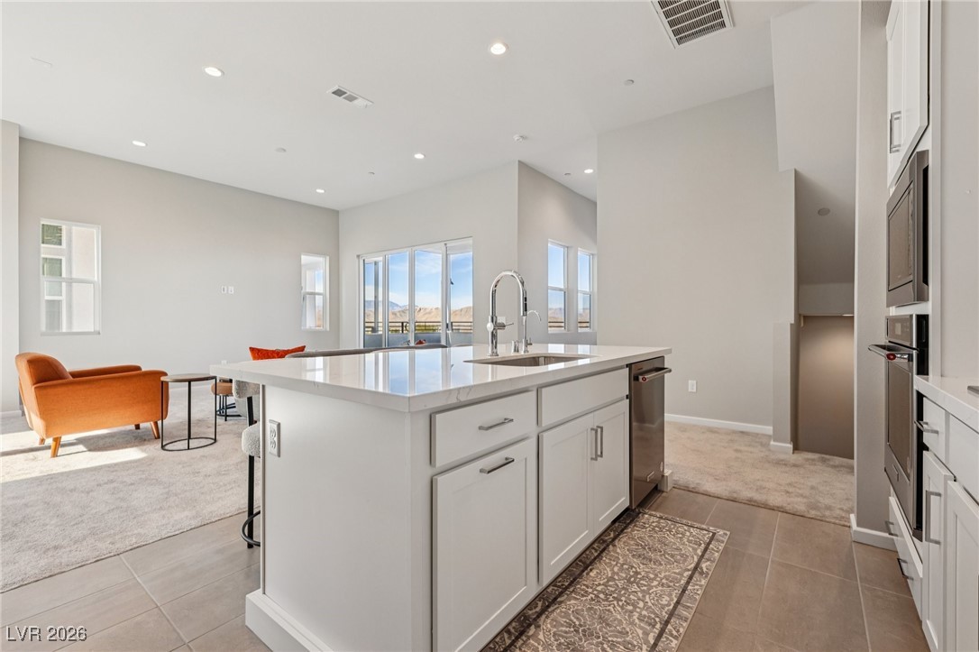 3338 Esker Rdg Avenue Henderson, NV 89044 - Photo 81 of 84 Kitchen featuring white cabinetry, an island with sink, light stone counters, open floor plan, and recessed lighting