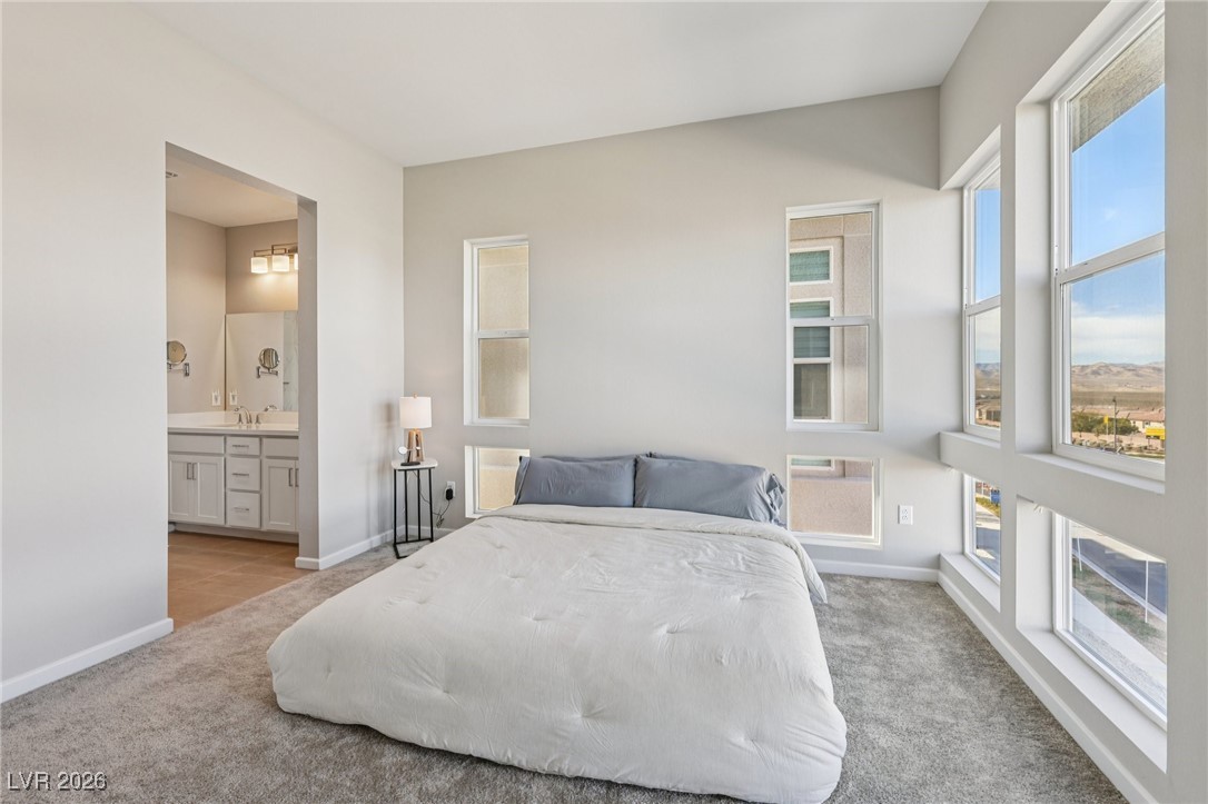 3338 Esker Rdg Avenue Henderson, NV 89044 - Photo 31 of 84 Bedroom featuring light carpet, multiple windows, and ensuite bath