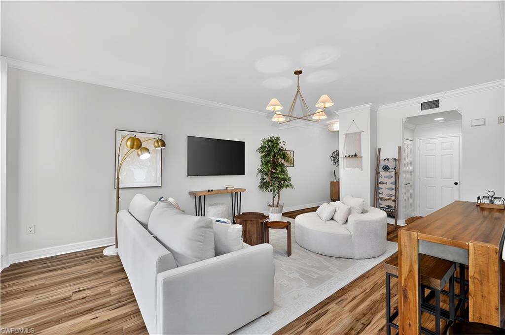 450 Bayfront Place, Unit 4202 Naples, FL 34102 - Photo 11 of 39 Living area featuring ornamental molding, hanging lights, and wood finished floors