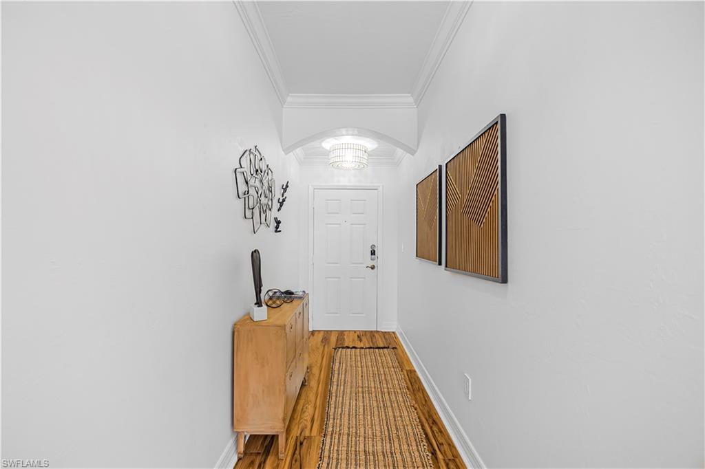 450 Bayfront Place, Unit 4202 Naples, FL 34102 - Photo 22 of 39 Doorway featuring ornamental molding, arched walkways, and wood finished floors
