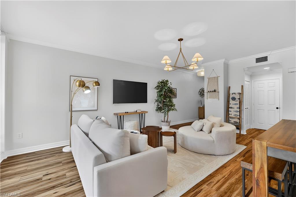 450 Bayfront Place, Unit 4202 Naples, FL 34102 - Photo 9 of 39 Living room with crown molding, suspended lighting, and wood finished floors
