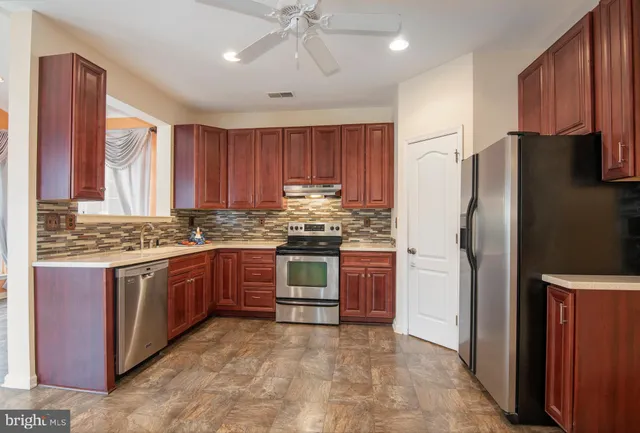a kitchen with stainless steel appliances granite countertop a refrigerator stove and sink