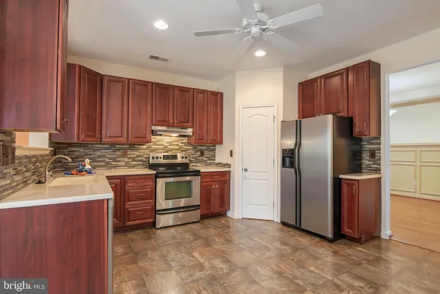 a kitchen with stainless steel appliances granite countertop a refrigerator a stove a sink and a microwave