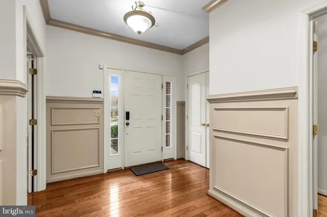 an empty room with wooden floor cabinet and a mirror