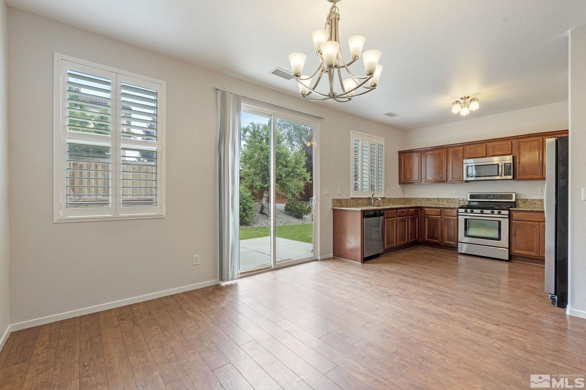 310 Pesaro Way Reno, NV 89521 - Photo 8 of 25 a open kitchen with stainless steel appliances granite countertop a stove top oven a sink and dishwasher with wooden floor