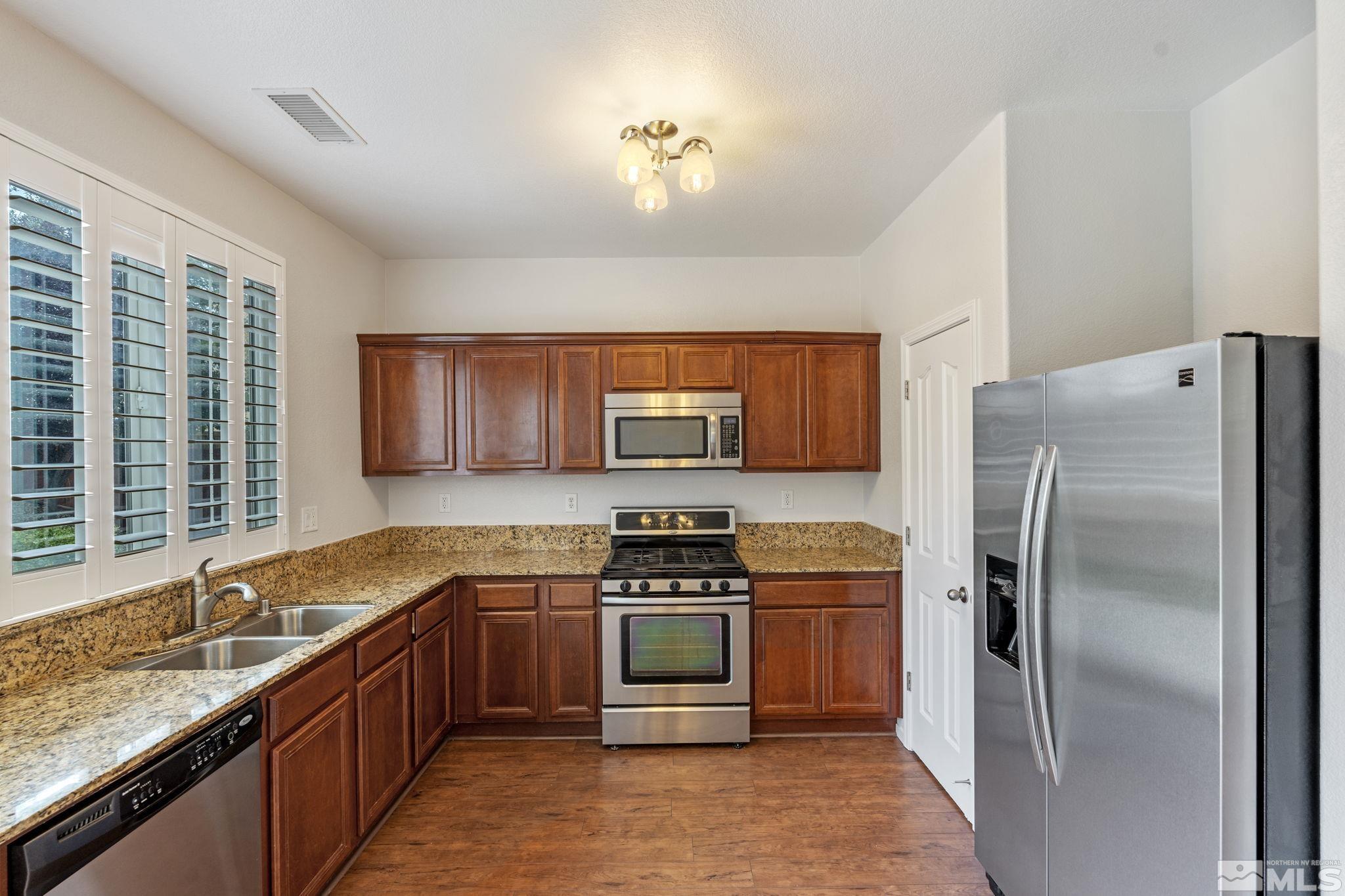 310 Pesaro Way Reno, NV 89521 - Photo 9 of 25 a kitchen with a sink stove and refrigerator