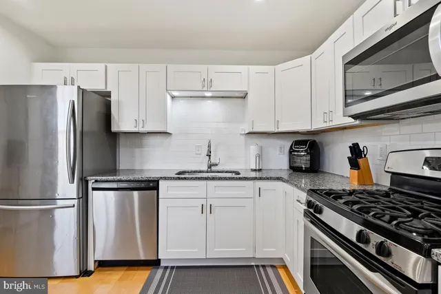 a kitchen with stainless steel appliances granite countertop a stove a refrigerator and a microwave