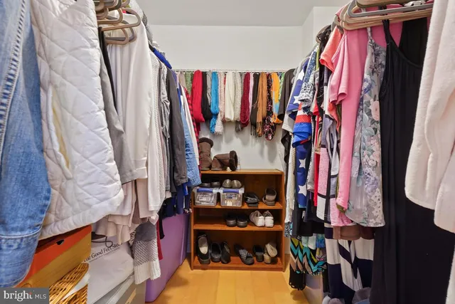 a view of walk in closet with clothes and shoes