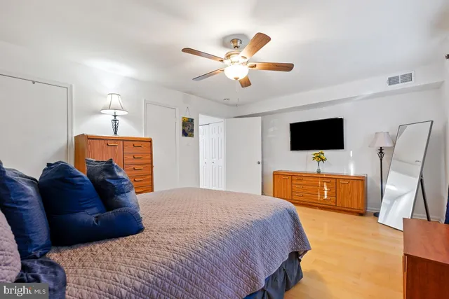 a bedroom with a bed flat screen tv and a couch