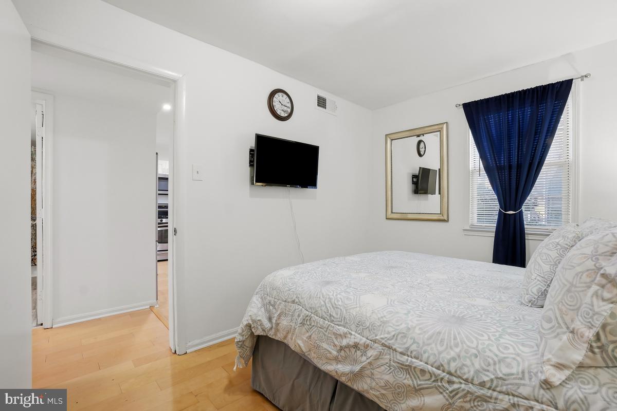 794 Quince Orchard Boulevard, Unit T2 Gaithersburg, MD 20878 - Photo 27 of 30 a bedroom with a large bed a flat tv screen and a closet