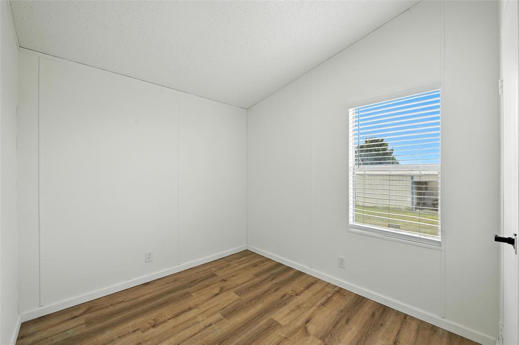 197 Pondview Drive Decatur, TX 76234 - Photo 19 of 28 a view of an empty room with wooden floor and a window
