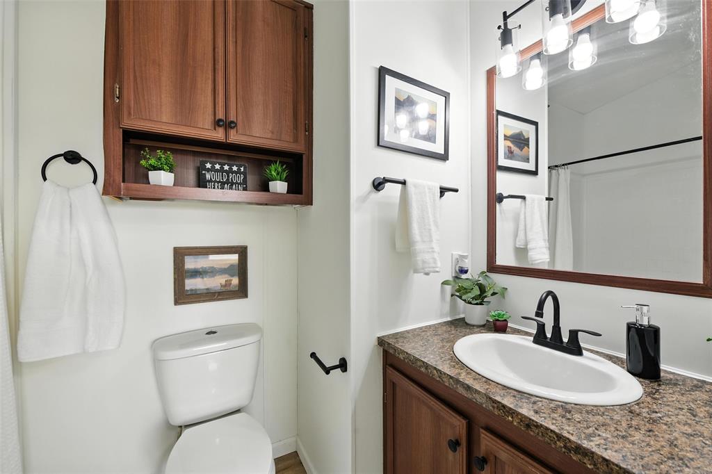 197 Pondview Drive Decatur, TX 76234 - Photo 20 of 28 a bathroom with a granite countertop sink toilet and a mirror