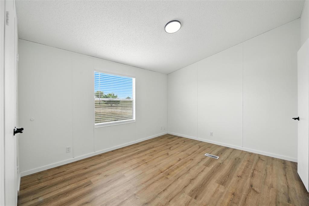 197 Pondview Drive Decatur, TX 76234 - Photo 23 of 28 an empty room with wooden floor and windows