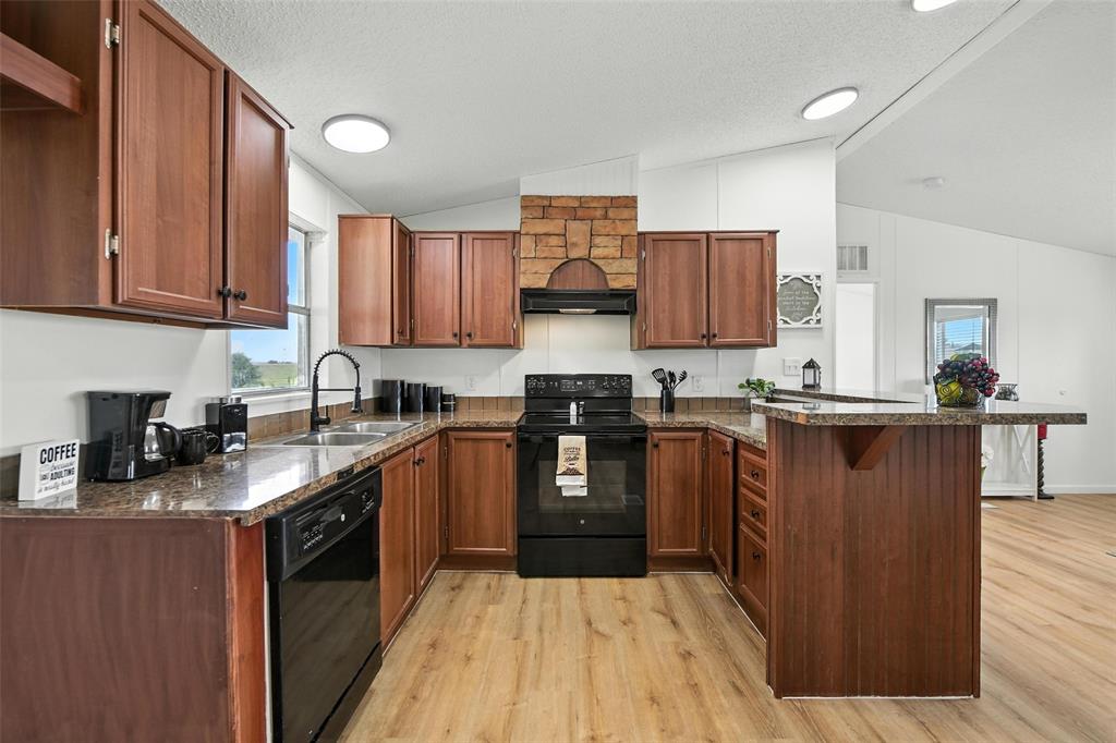 197 Pondview Drive Decatur, TX 76234 - Photo 10 of 28 a kitchen with granite countertop wooden cabinets and stainless steel appliances