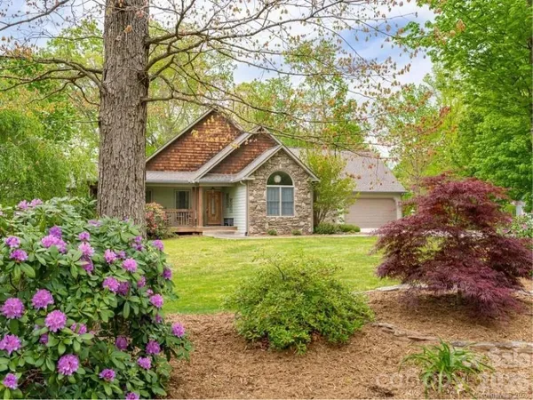 a front view of a house with a yard and fountain