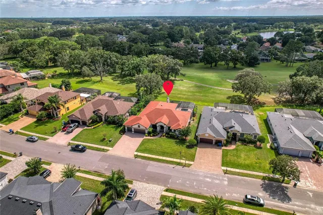 an aerial view of a house with a garden and lake view