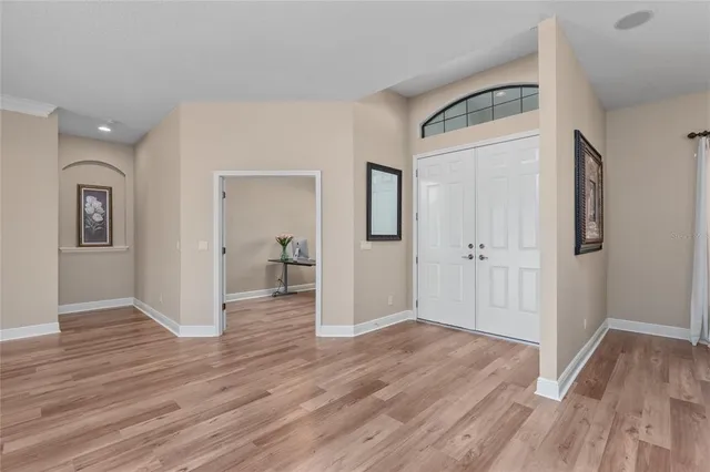 a dining room with furniture a chandelier and wooden floor