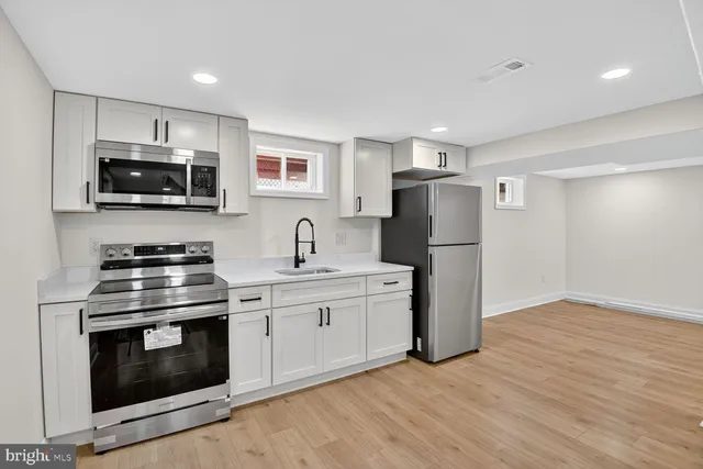 a kitchen with stainless steel appliances a stove microwave and refrigerator
