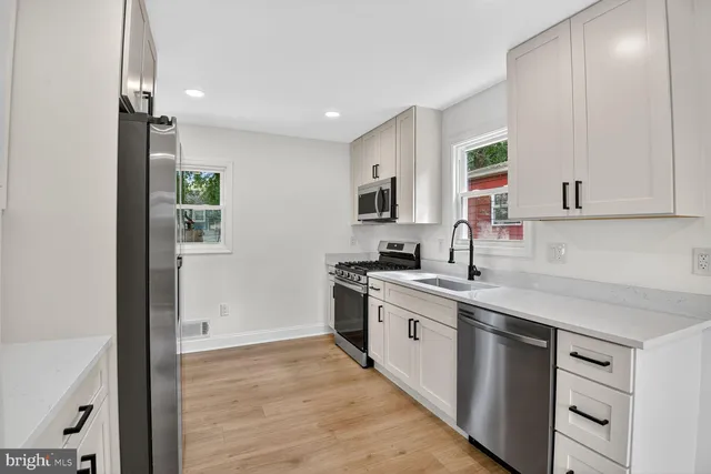 a kitchen with stainless steel appliances granite countertop a sink and a stove top oven