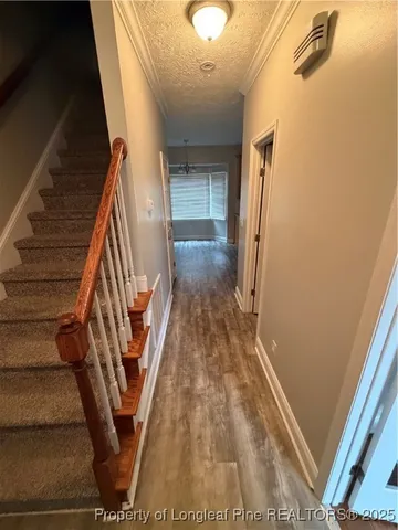 a view of an empty room with wooden floor and next to a window
