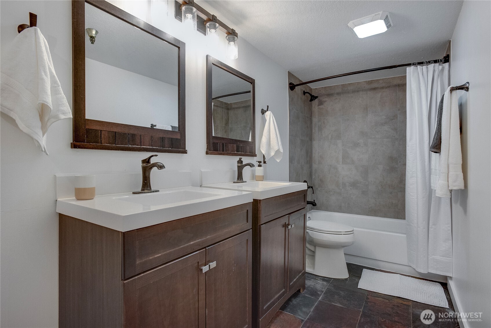 1100 Harrington Avenue Northeast, Unit 310 Renton, WA 98056 - Photo 28 of 40 a bathroom with a sink toilet a mirror a vanity and shower