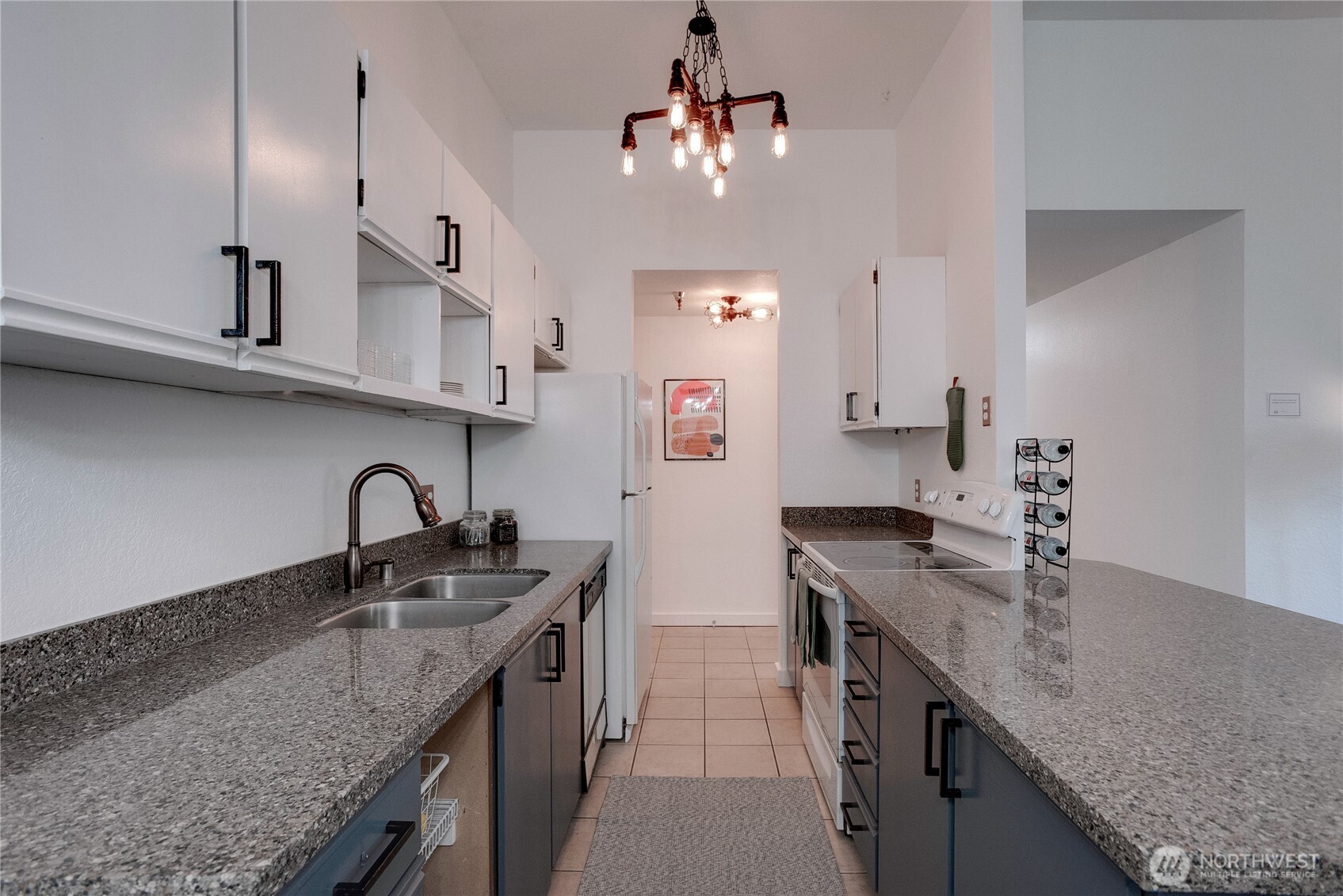 1100 Harrington Avenue Northeast, Unit 310 Renton, WA 98056 - Photo 5 of 40 a kitchen with kitchen island granite countertop a sink a counter space appliances and cabinets