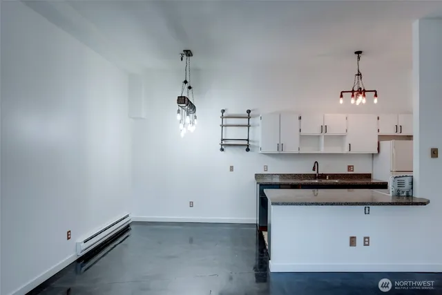 a view of a kitchen with cabinets appliances and wooden floor