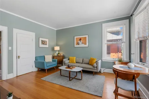a living room with furniture wooden floor and a table