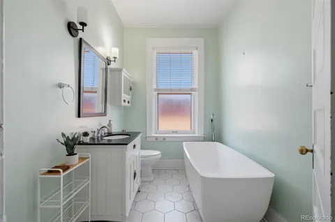 a bathroom with a sink and mirror with toilet