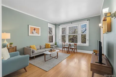 a living room with furniture and a flat screen tv with wooden floor