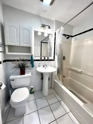 a bathroom with a sink toilet a mirror and bathtub
