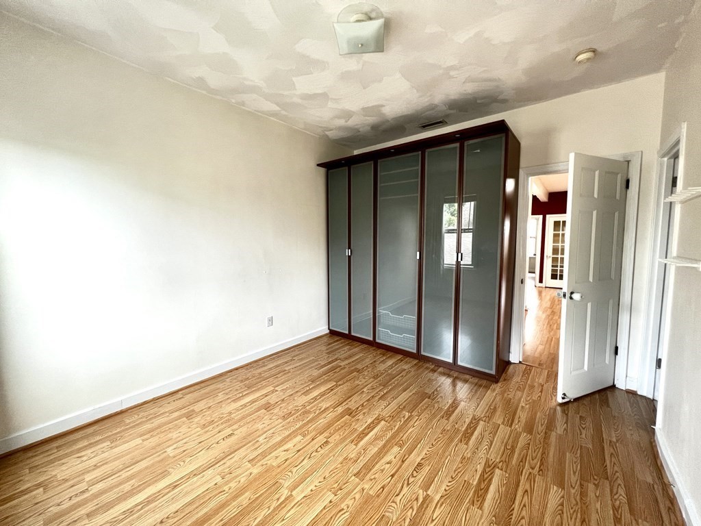40-42 Winter Street, Unit 3 Boston, MA 02111 - Photo 9 of 12 an empty room with wooden floor and windows