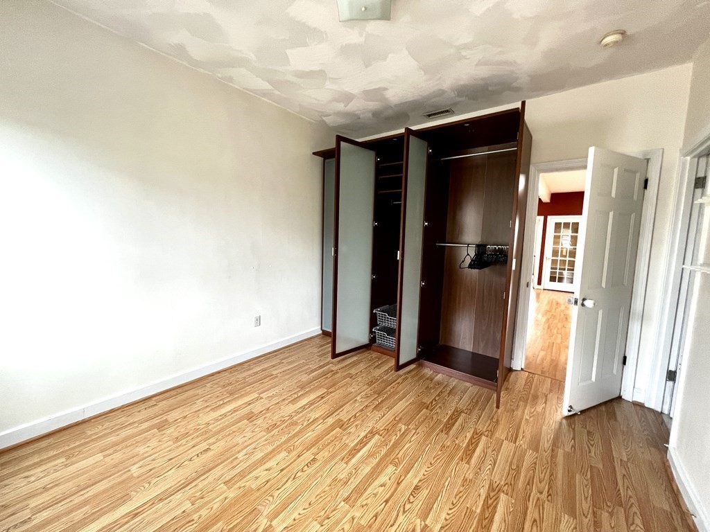 40-42 Winter Street, Unit 3 Boston, MA 02111 - Photo 10 of 12 a view of an empty room with wooden floor and a bathroom