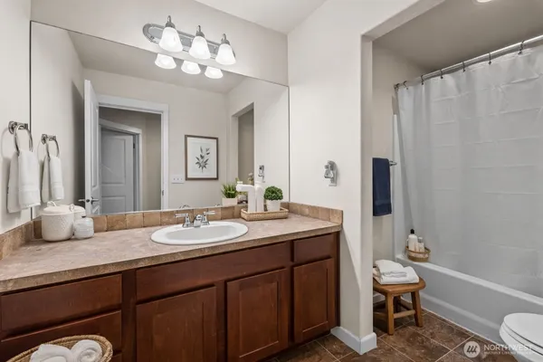 a bathroom with a granite countertop sink a toilet and a mirror