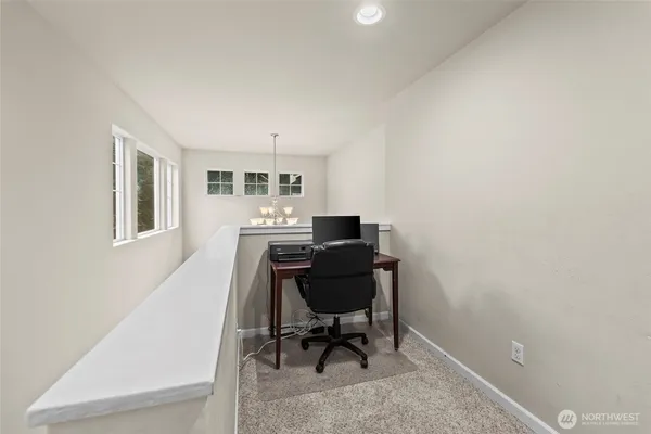 a view of a workspace with furniture and a window