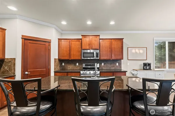 a kitchen with a dining table chairs and refrigerator